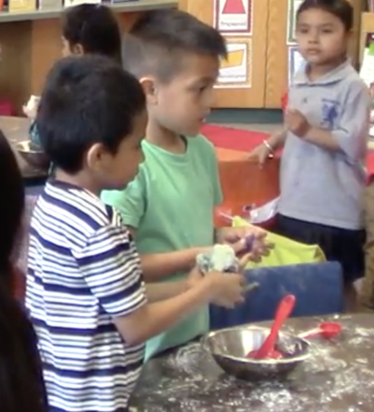 Children mixing ingredients in a bowl.