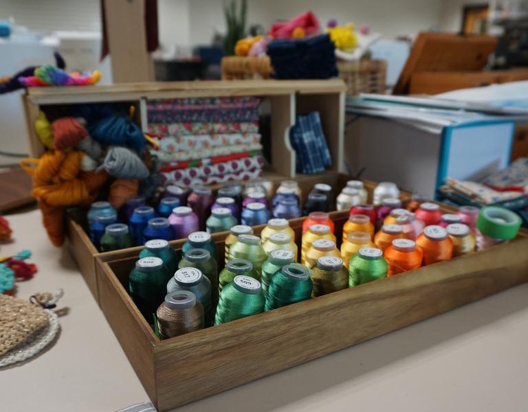 Various spools of colored thread in a box