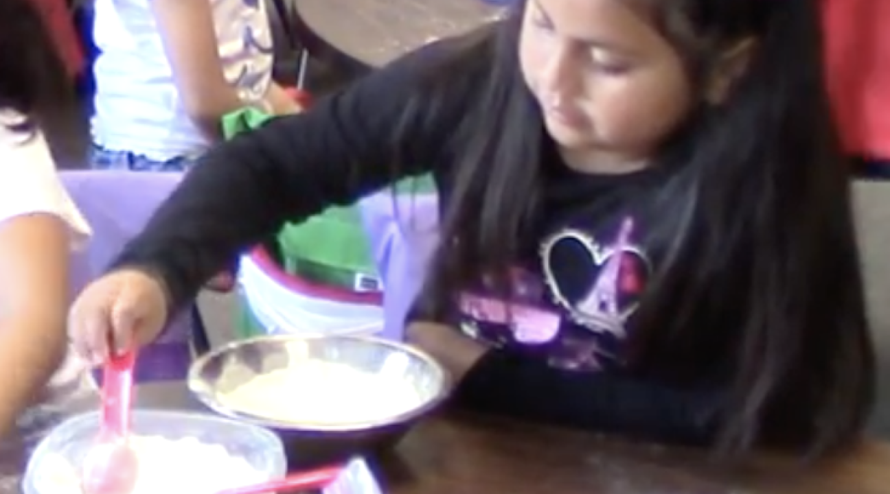 Child mixing ingredients in a bowl.