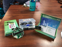 3 opens boxes on a table.  The boxes contain electronics and documentation.