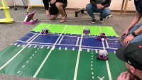 4 cars are on an canvas on the floor.