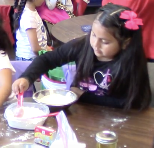 Child mixing ingredients in a bowl.