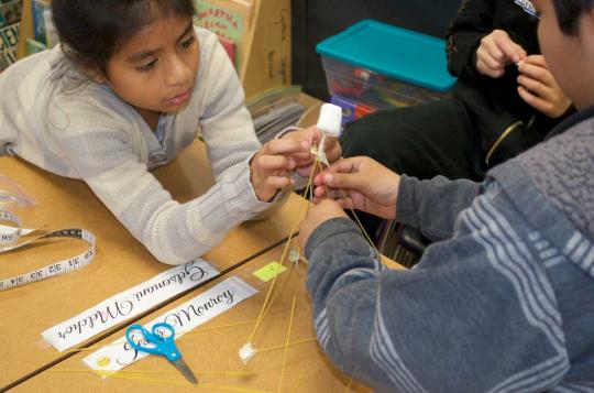Two people creating a structure.